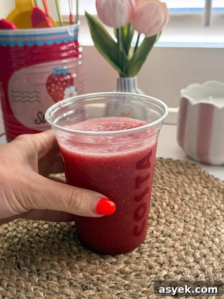 Strawberry, Watermelon & Mint Refresher served in a clear Costa plastic cup with a straw.