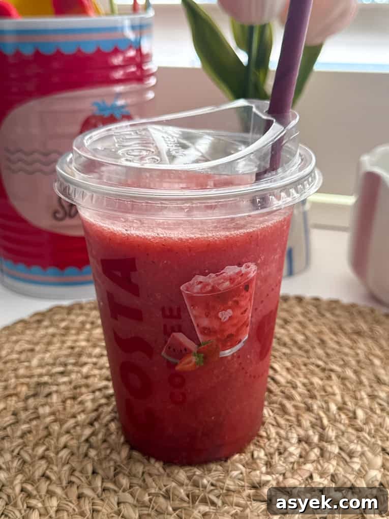 Strawberry, Watermelon & Mint Refresher served in a clear Costa plastic cup with a straw.