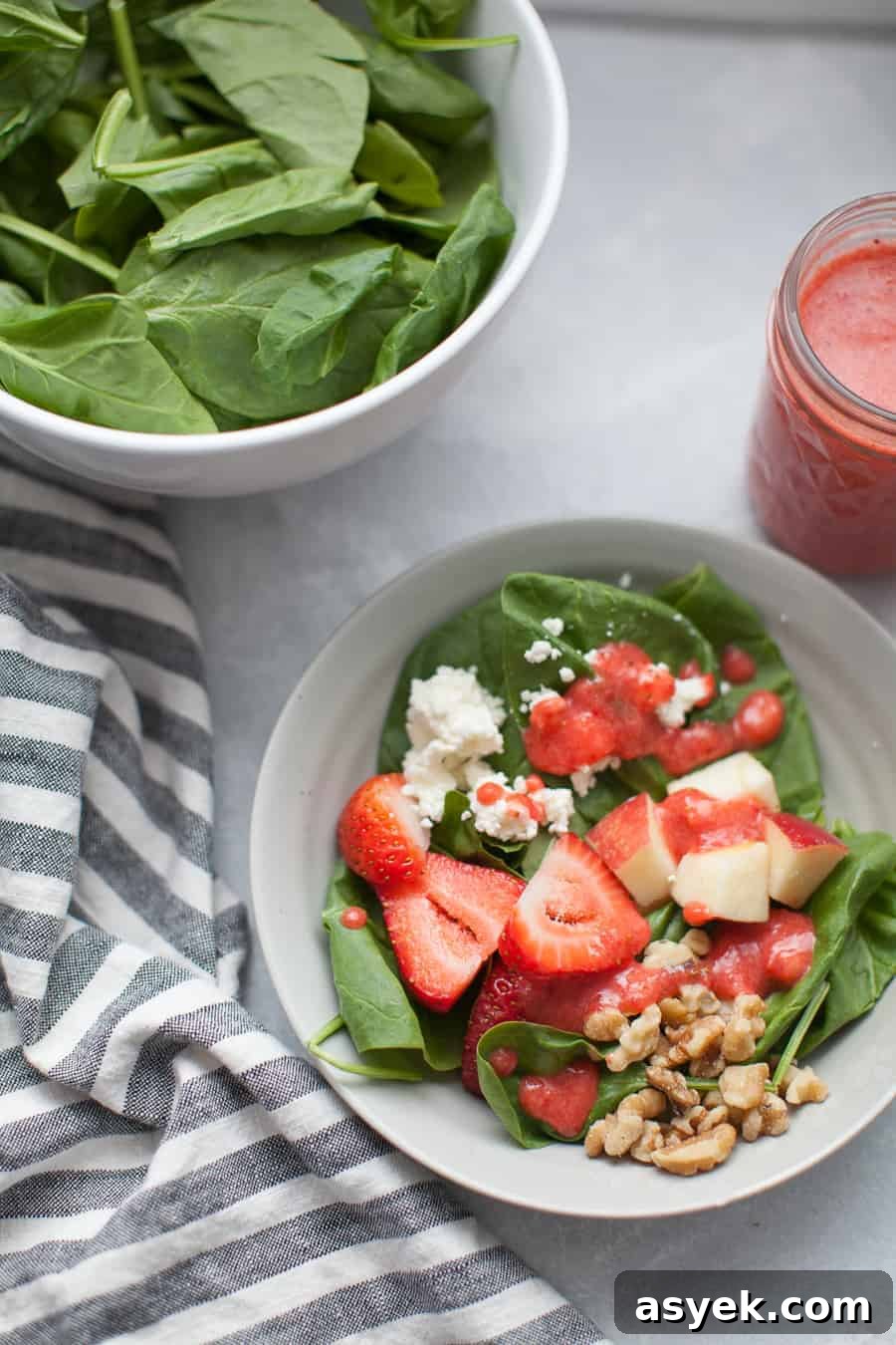 Strawberry Spinach Salad with Balsamic Vinaigrette 3 Strawberry and spinach salad served on a plate, topped with walnuts and feta.