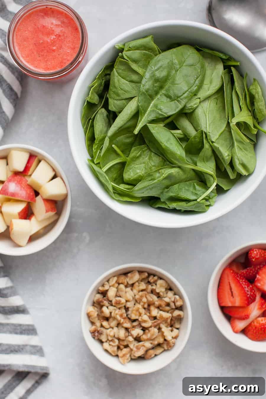 Strawberry Spinach Salad with Balsamic Vinaigrette 4 Close-up of strawberry spinach salad showing strawberries, apple and walnuts.
