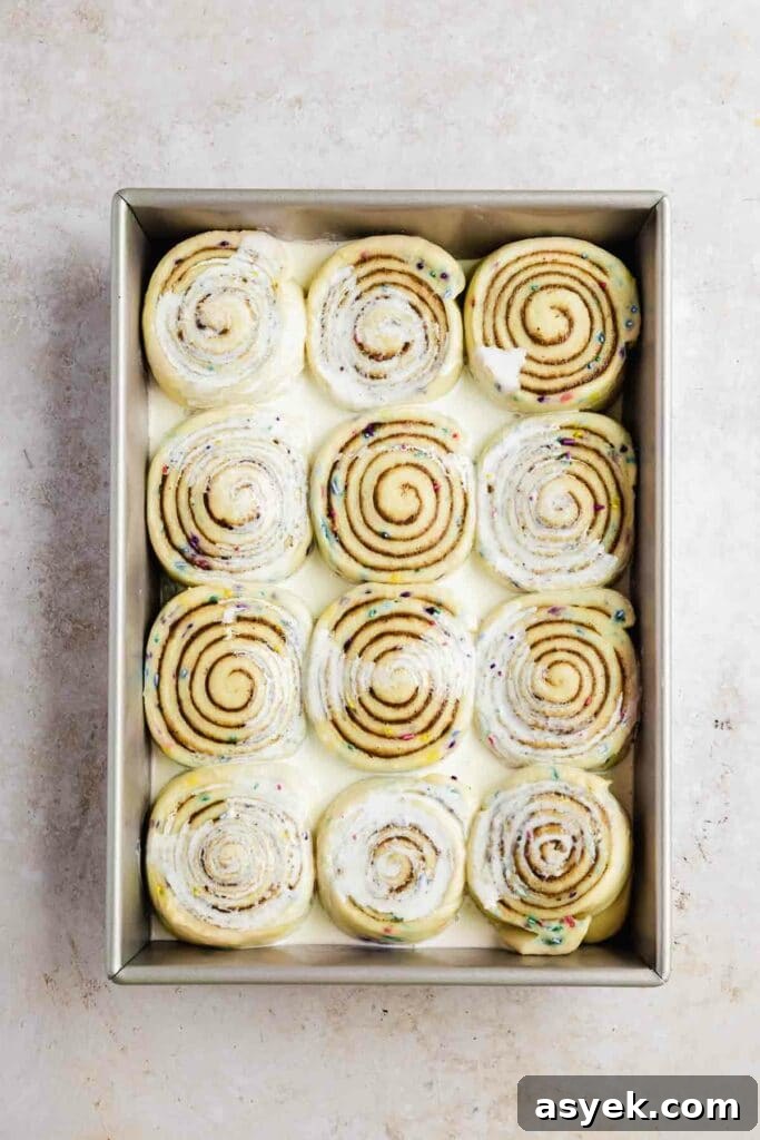 Cream poured onto risen and unbaked cinnamon rolls