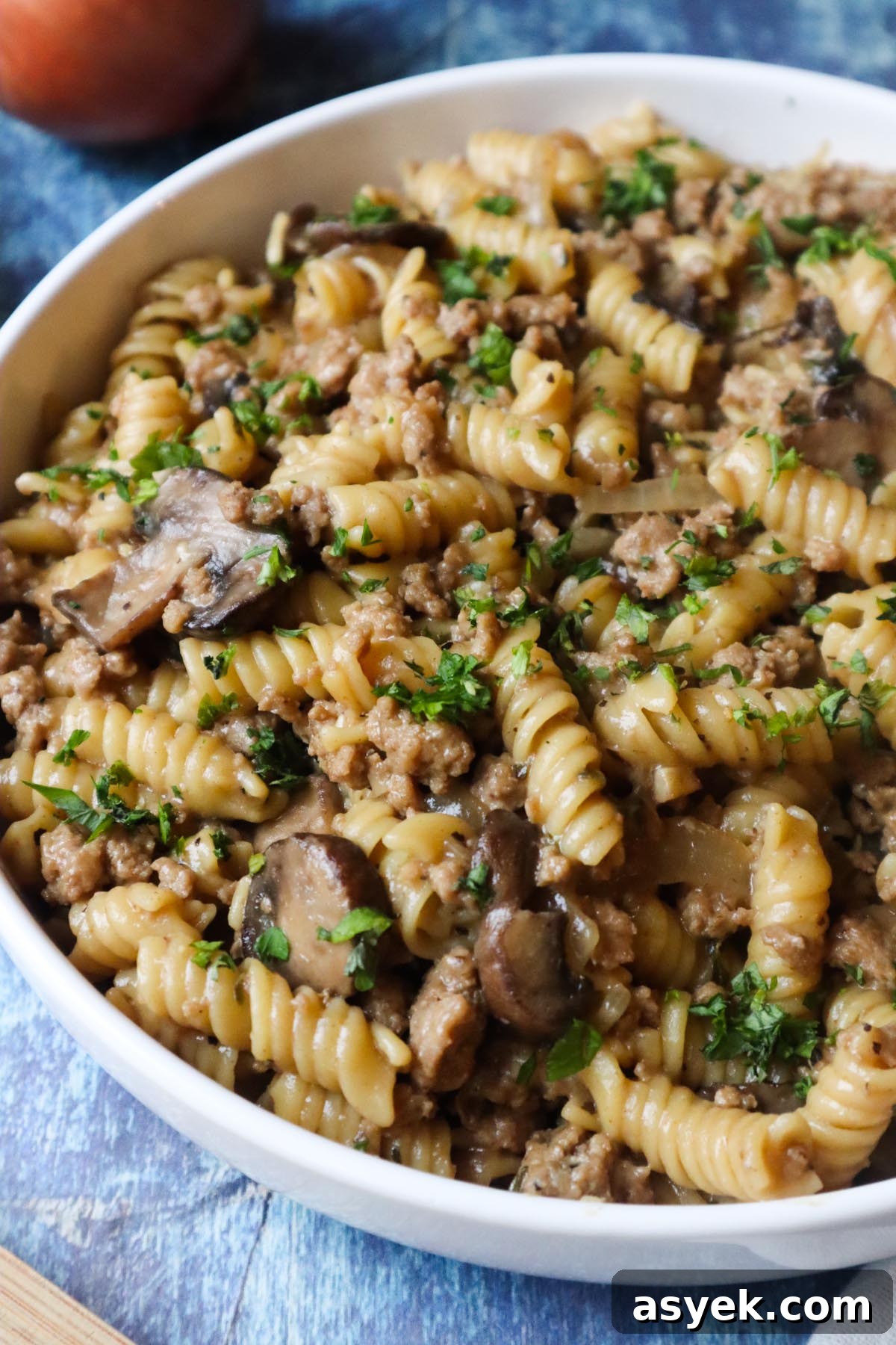 white plate with french onion pasta topped with fresh parsley