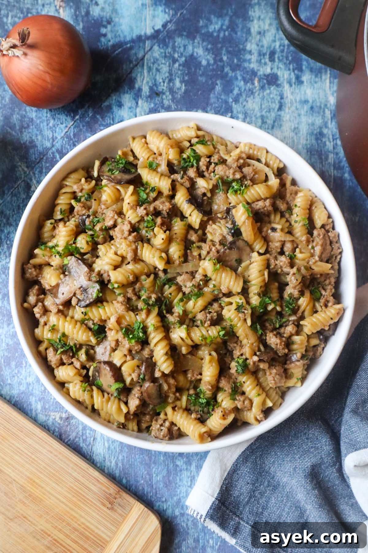 white plate with french onion pasta topped with fresh parsley