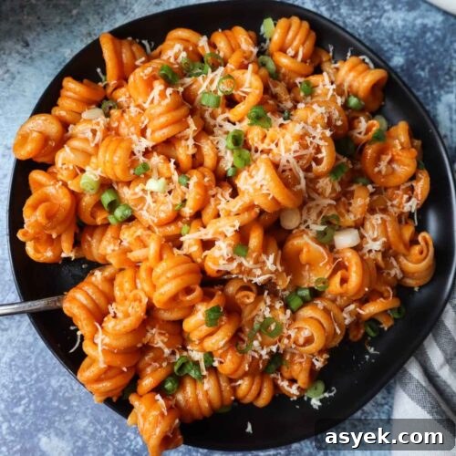 black plate with gochujang pasta with a blue background