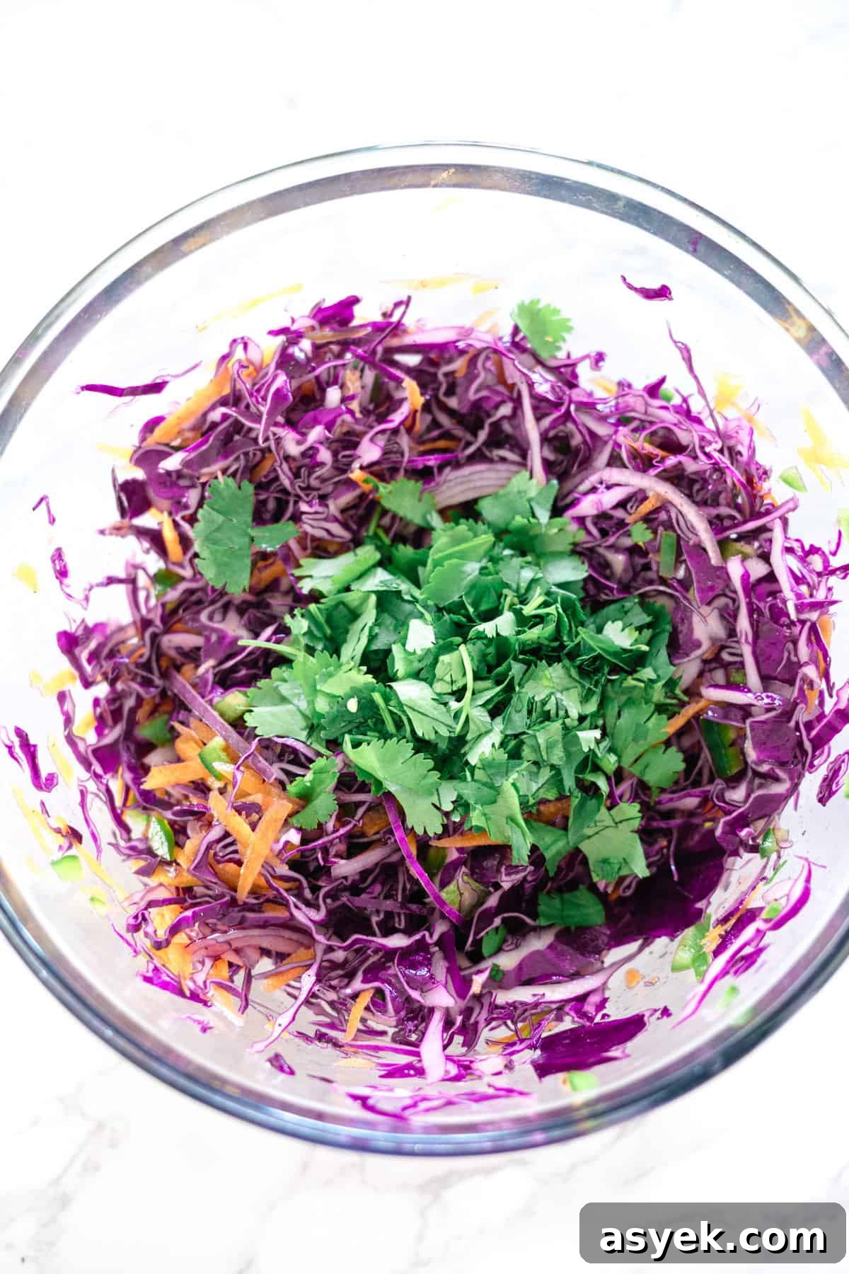 Purple Cabbage Coleslaw Recipe with Zesty Dressing 6 Purple cabbage slaw in a glass bowl.