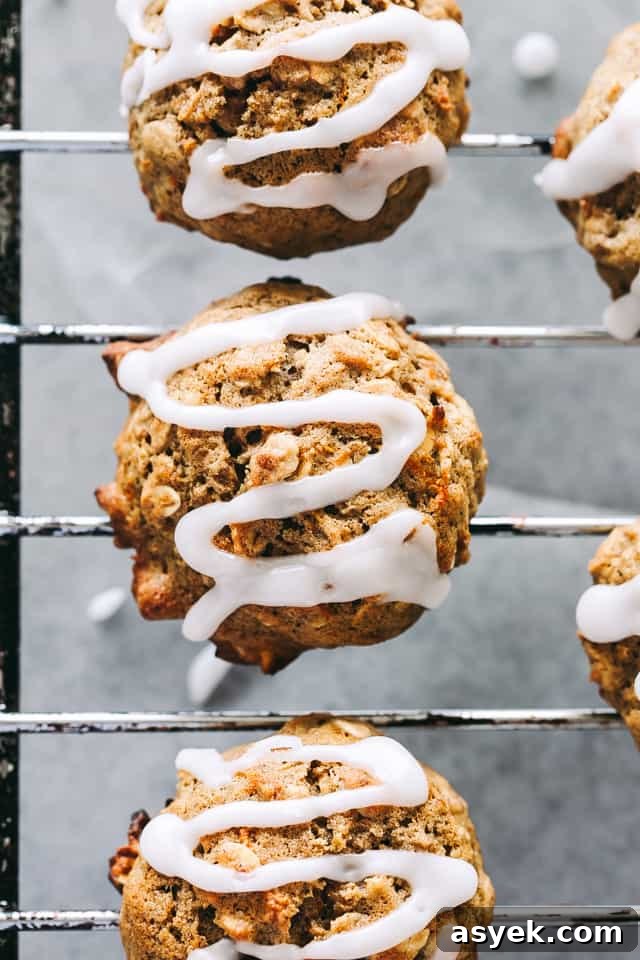Chewy Carrot Cake Cookies with Cream Cheese Frosting 5 Carrot oatmeal cookies topped with a drizzle of pineapple icing on a wire rack.