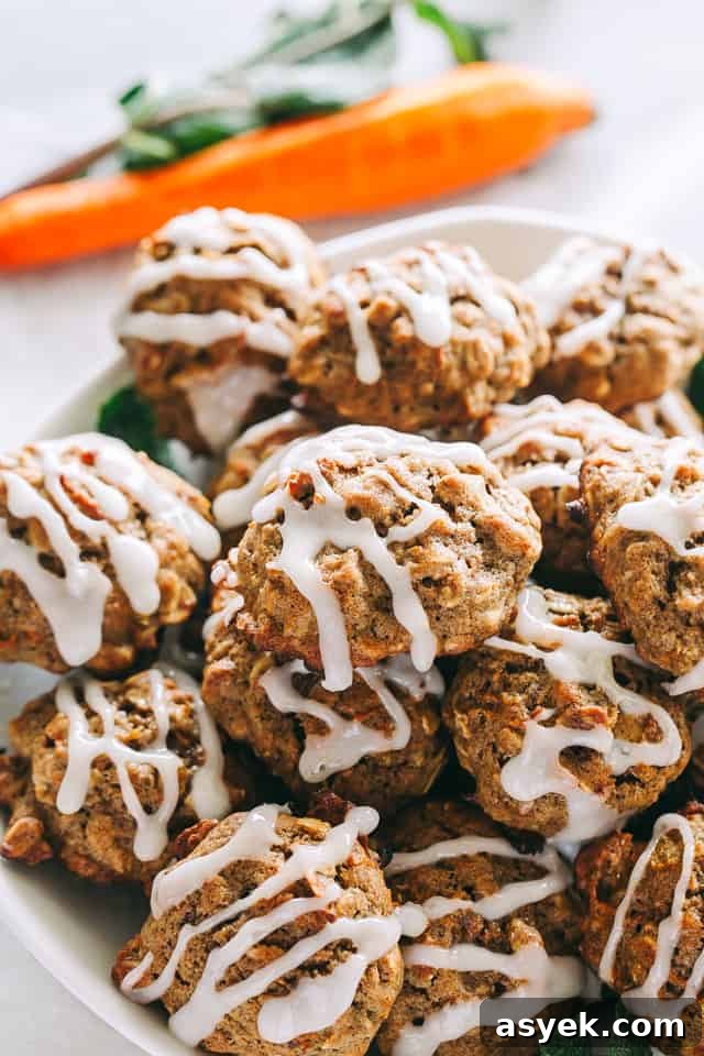 Chewy Carrot Cake Cookies with Cream Cheese Frosting 6 Homemade carrot cake cookies drizzled with pineapple icing, stacked in a bowl.