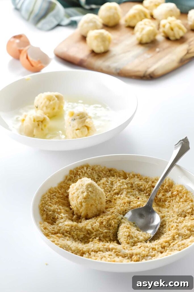 Cold mac and cheese balls coated in breadcrumbs in bowl.