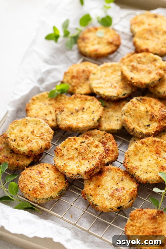 Crispy Air Fryer Zucchini Chips Recipe 2 Air fryer zucchini chips on a wire rack set on a rimmed baking sheet.
