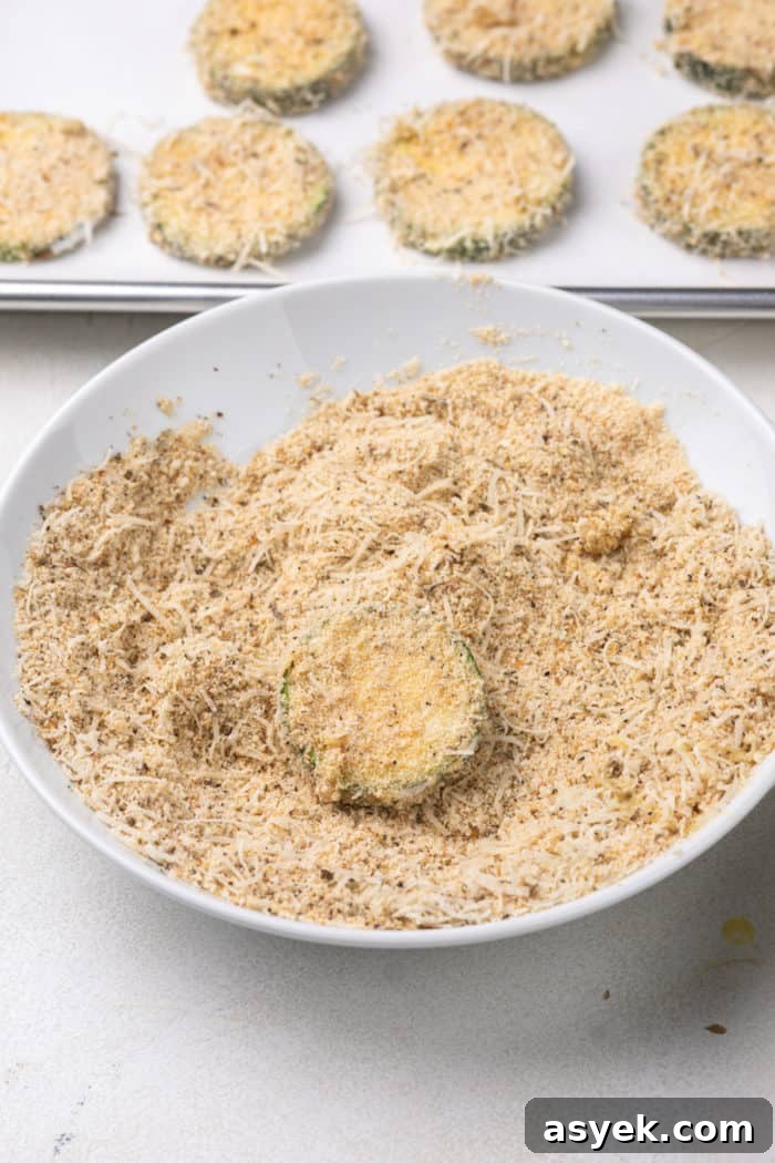Crispy Air Fryer Zucchini Chips Recipe 8 Zucchini round being coated in breadcrumb coating.