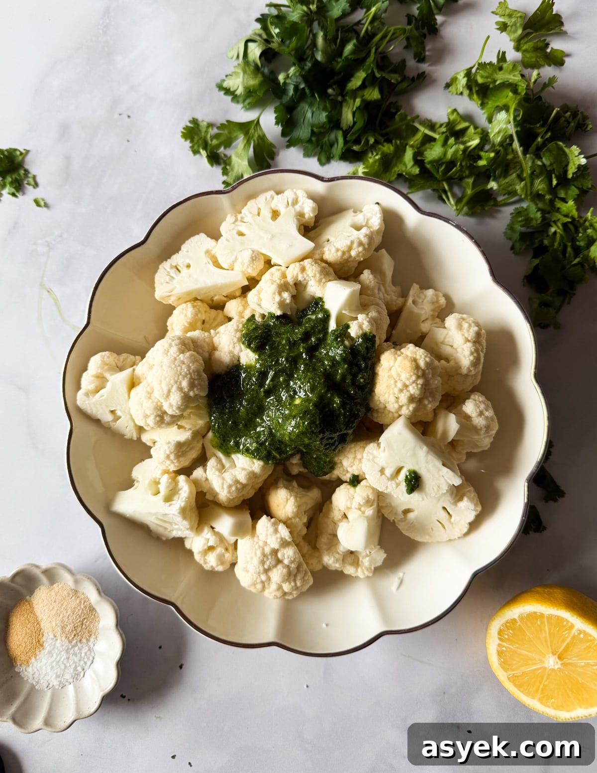 a bowl of cauliflower with herb oil on top. 