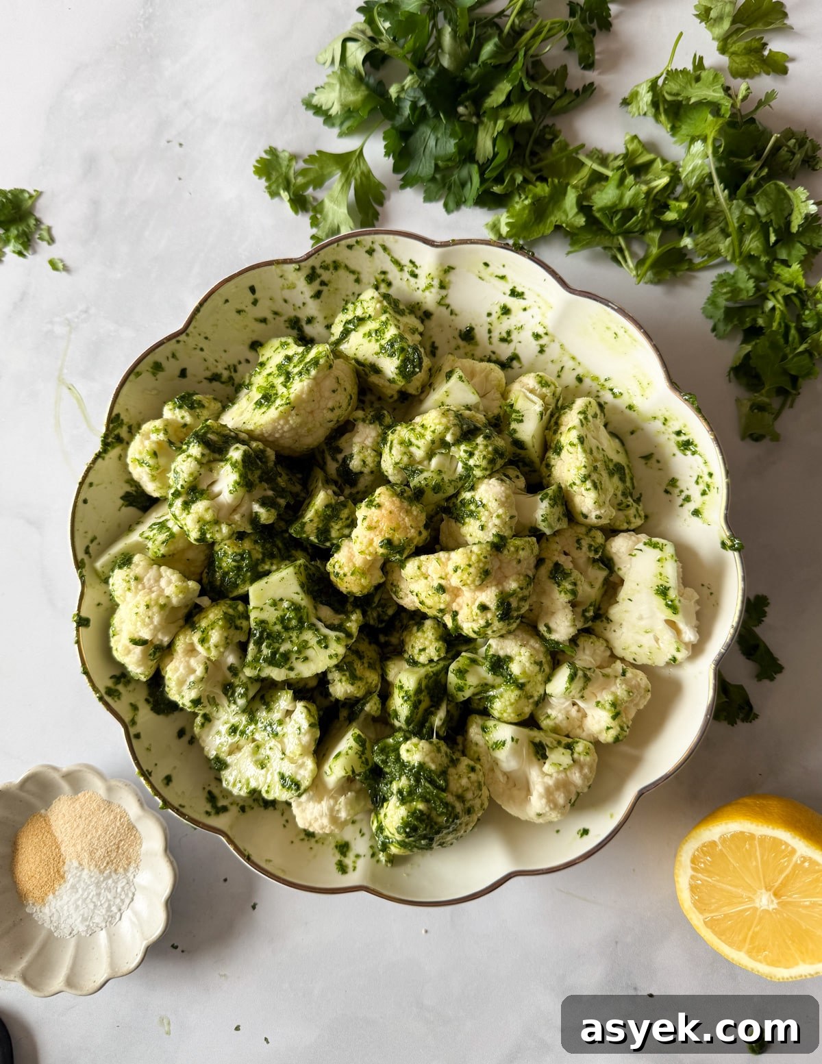 a bowl of cauliflower florets tossed in herb oil. 