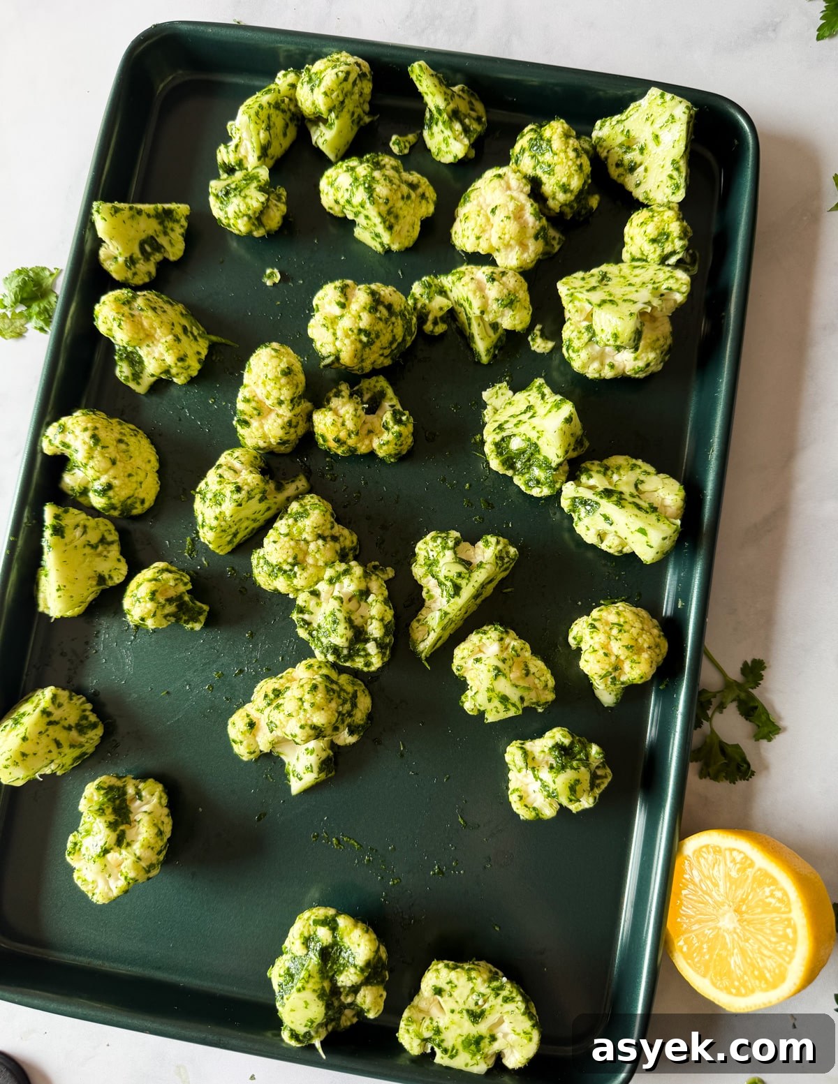 herb oil coated cauliflower florets on a sheet pan. 
