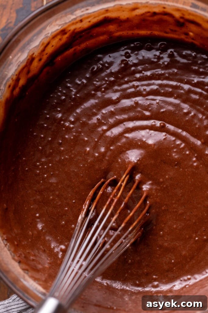 Chocolate cake batter in a glass bowl.