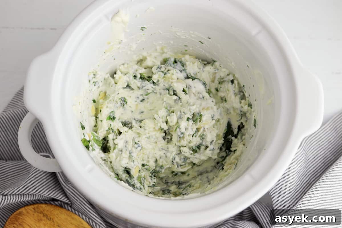 Creamy Slow Cooker Spinach and Artichoke Dip 4 ingredients stirred together in the crockpot