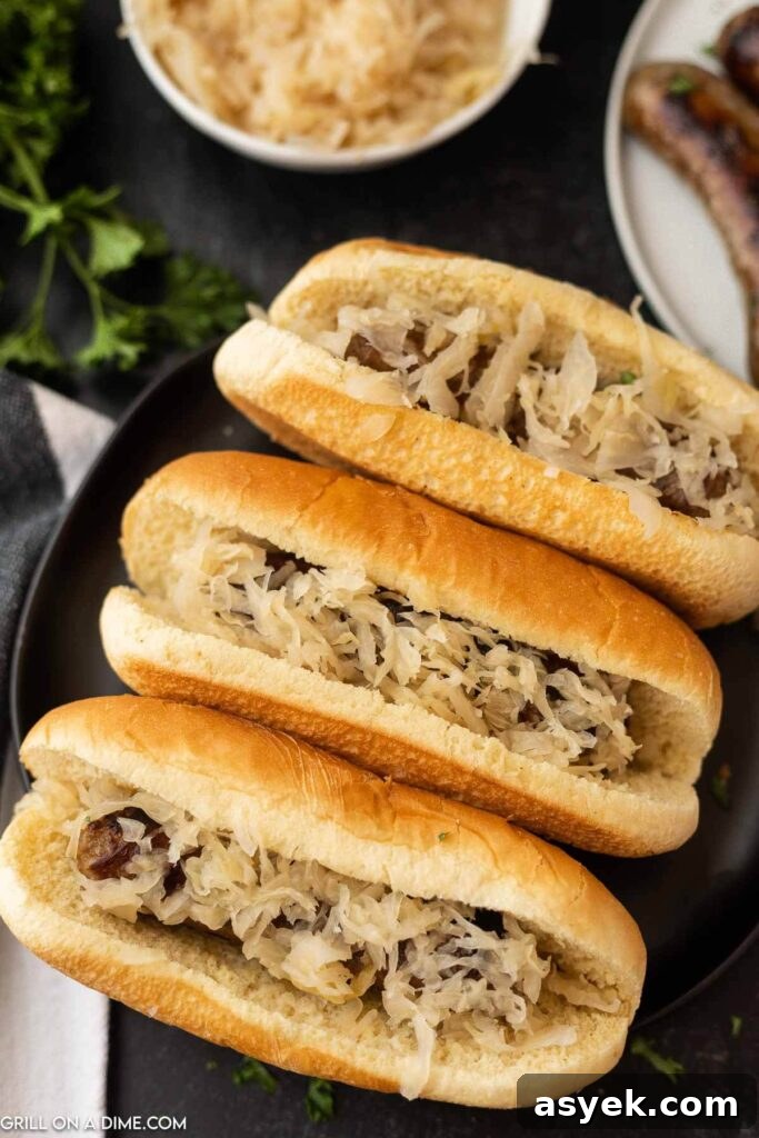 grilled brats in a hot dog bun topped with sauerkraut 