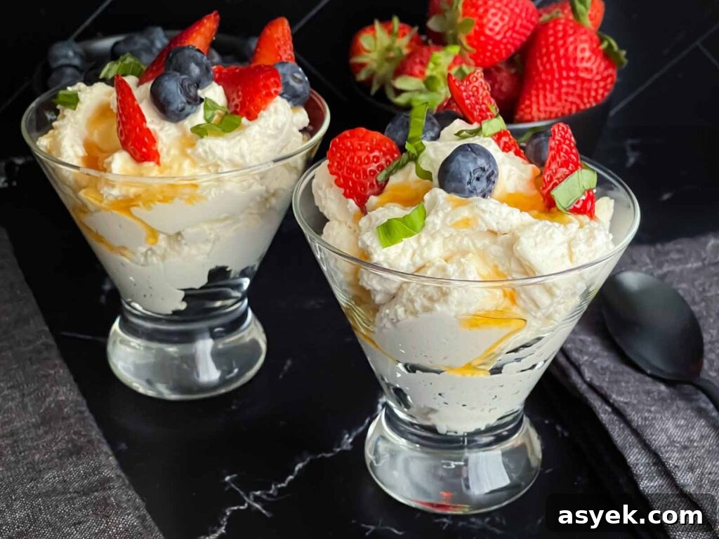 Silky Ricotta Mousse Recipe with Lemon and Honey 2 Ricotta mousse in a stemless martini glass garnished with strawberries, blueberries, basil, and honey.