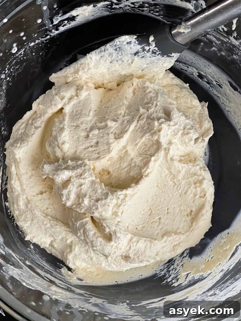 Silky Ricotta Mousse Recipe with Lemon and Honey 7 Ricotta mixture folded into the whipped cream in a glass mixing bowl.