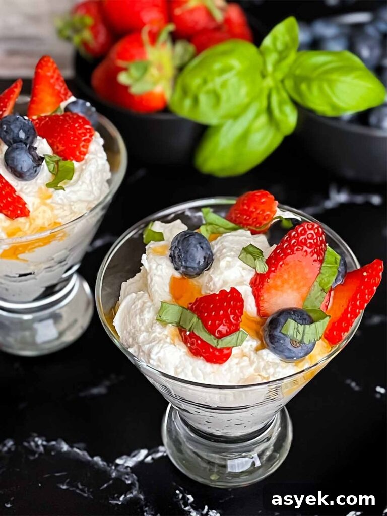 Silky Ricotta Mousse Recipe with Lemon and Honey 8 Ricotta mousse in a stemless martini glass garnished with strawberries, blueberries, basil, and honey.