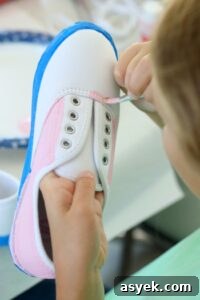 child painting shoes with acrylic paint