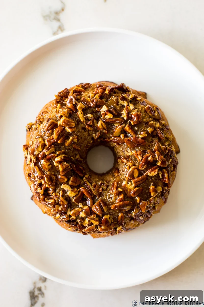 Classic Pecan Pie Bundt Cake Recipe 8 Overhead photo of a bundt cake on a white platter.