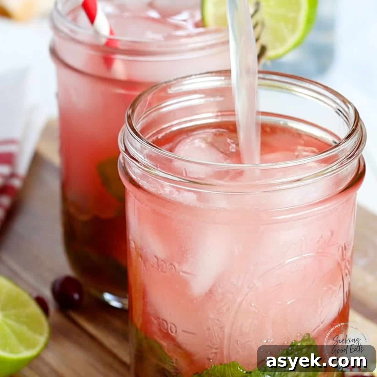 Cranberry Mojito Cocktail with Fresh Lime and Mint 5 Pouring tonic water over the cranberry mojito.