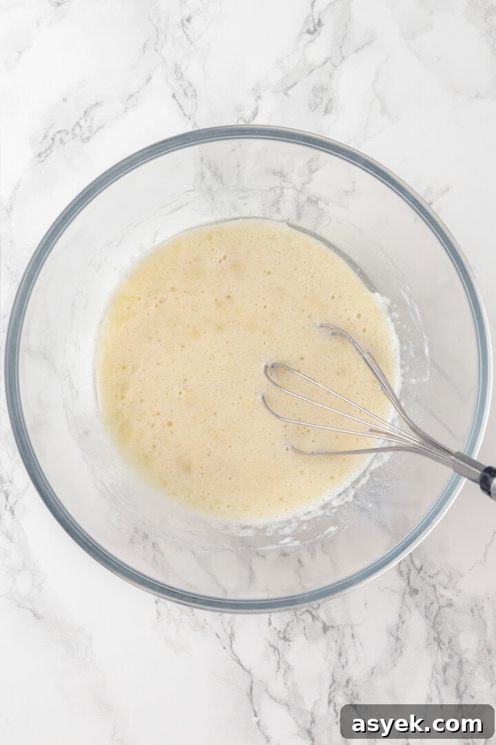 Wet ingredients in mixing bowl with whisk