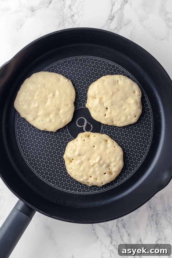 Vegan banana pancakes in skillet before flipping