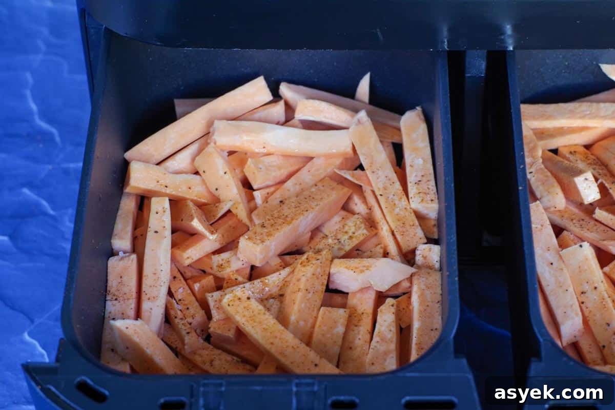 raw sweet potato fries in a drawer of air fryer