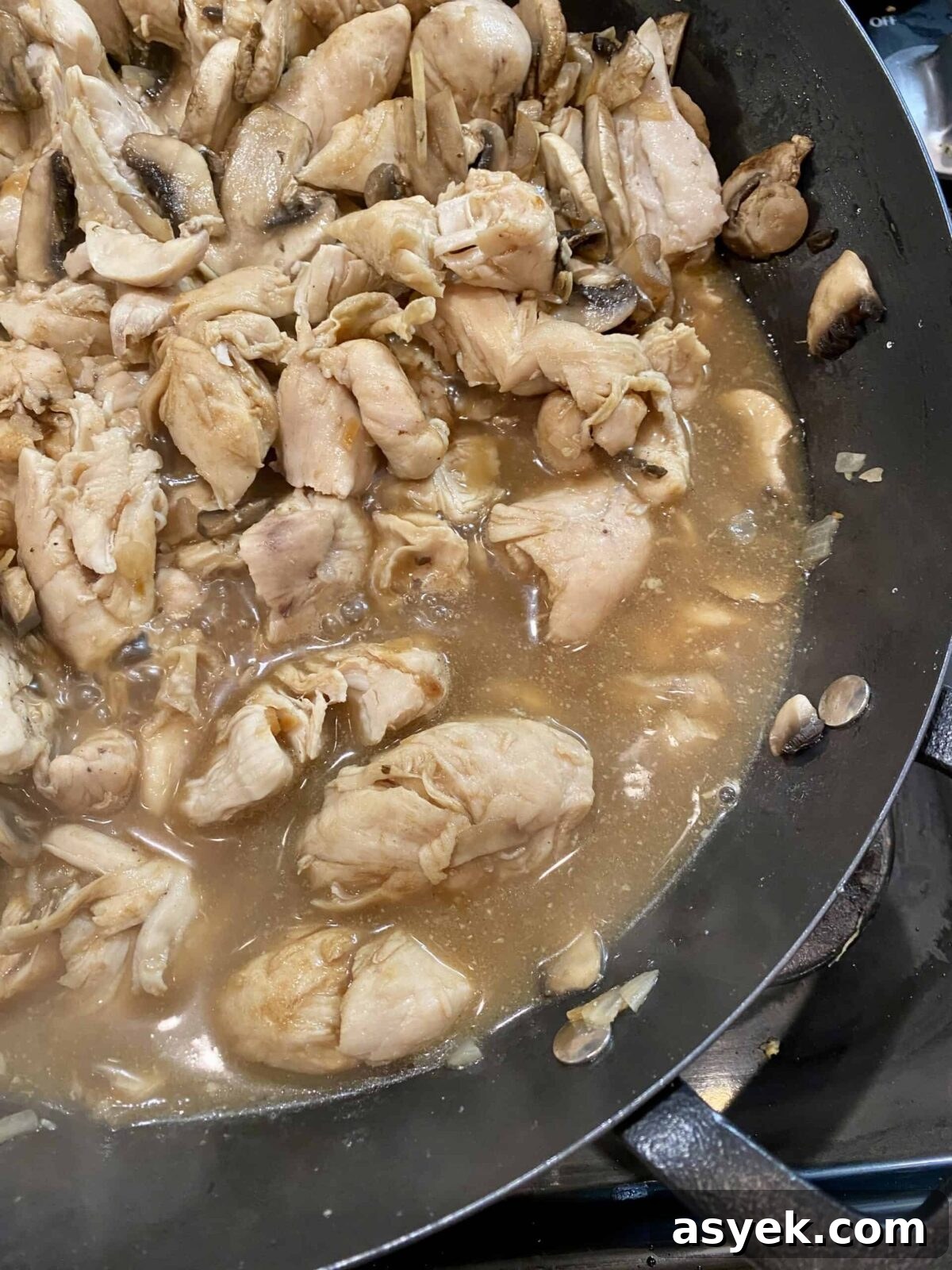 Simmering sauce with chicken in a skillet on the stove