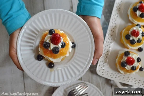Individual baba filled with whipped cream and topped with berries