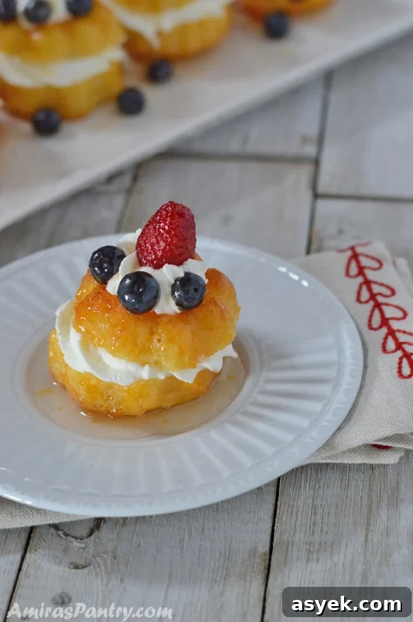 Individual baba filled with whipped cream and topped with berries