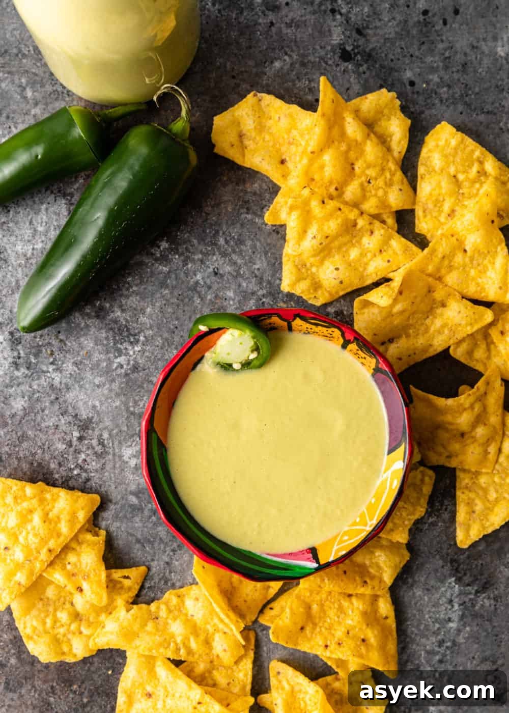overhead image: chips and green chili peppers surrounding bowl of jalapeno cream sauce