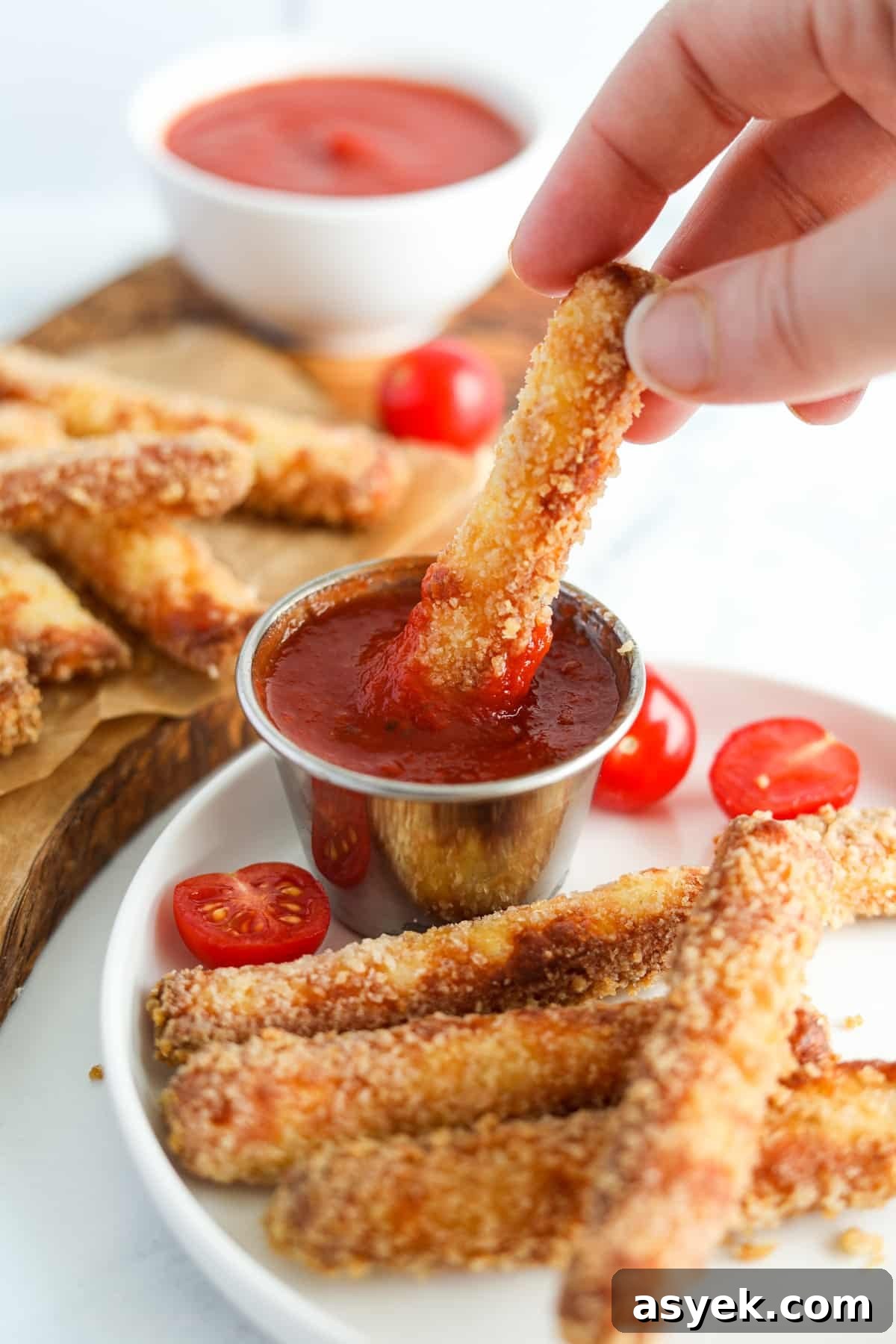 Crispy Air Fryer Halloumi Fries 7 Dipping a halloumi fry into marinara sauce.