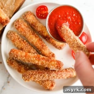 Dipping a breaded halloumi fry into pizza sauce.