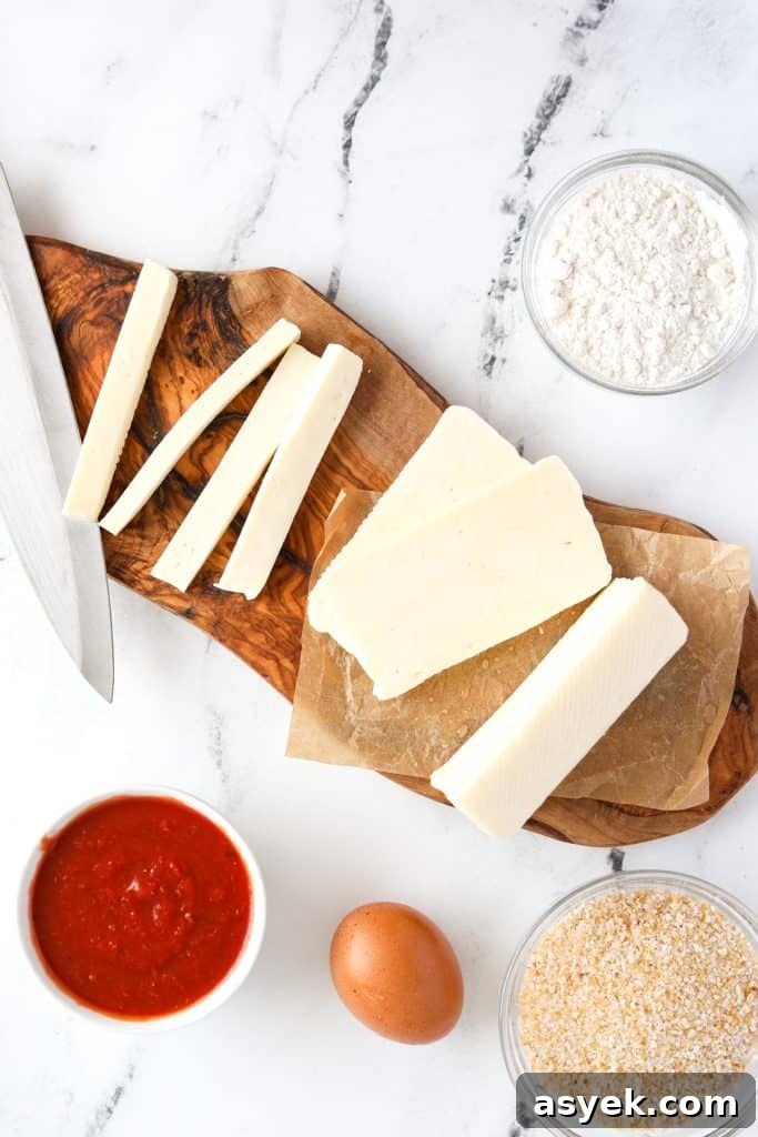 Crispy Air Fryer Halloumi Fries 4 A cutting board with cheese cut into sticks.