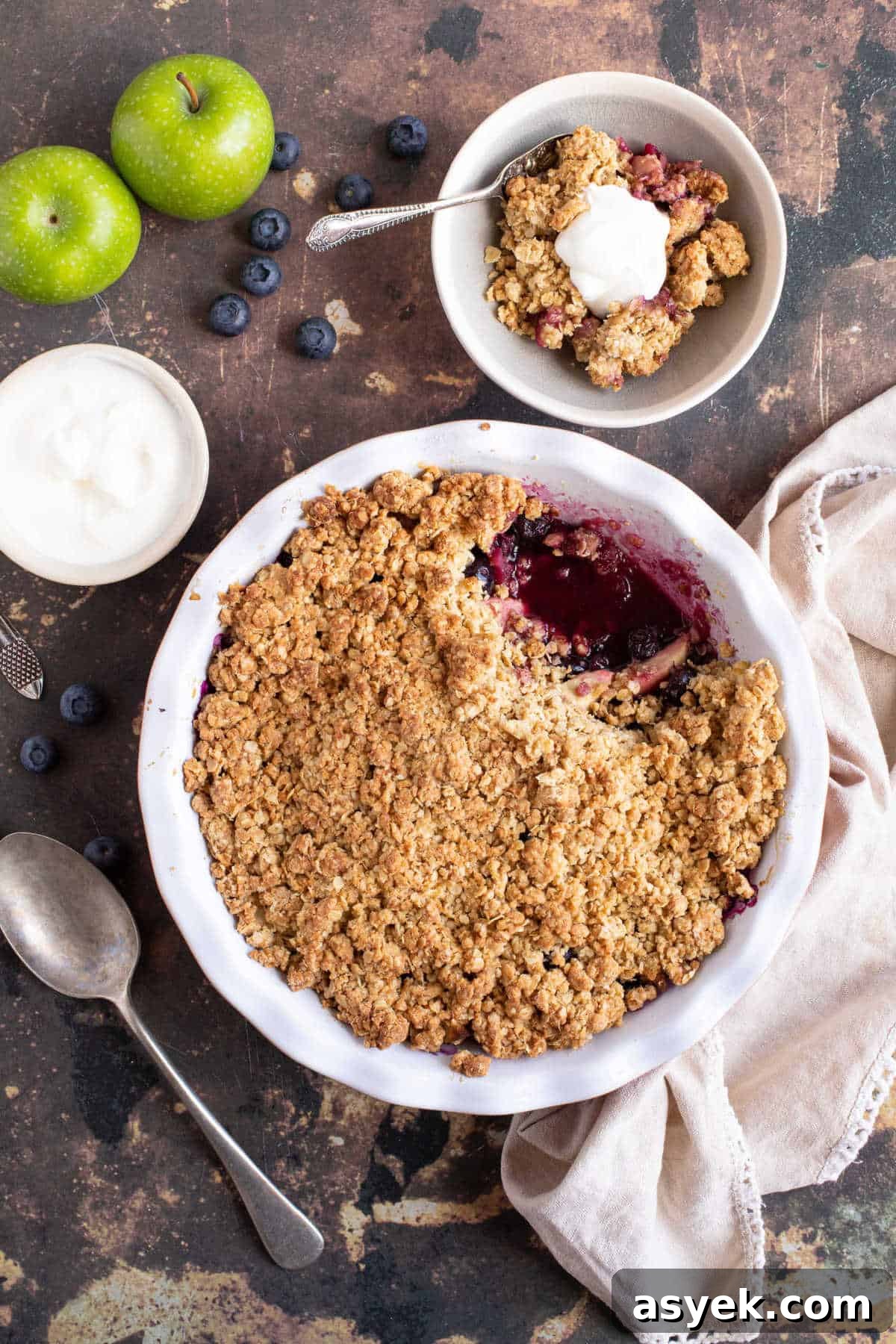 Classic Apple and Blueberry Crumble Recipe 8 Apple and blueberry crumble in a bowl served with yogurt.
