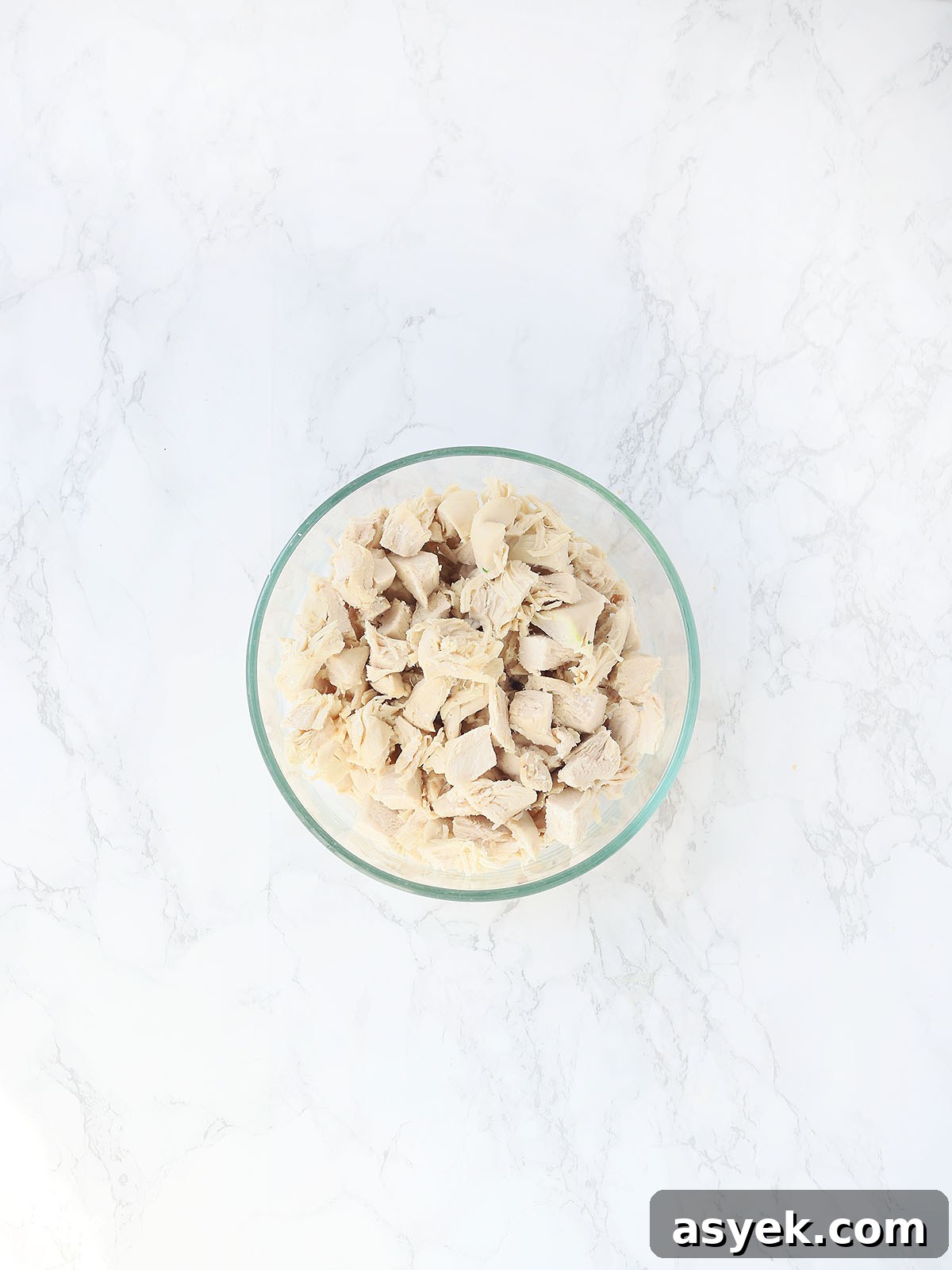 cooked and diced chicken breasts in a glass bowl