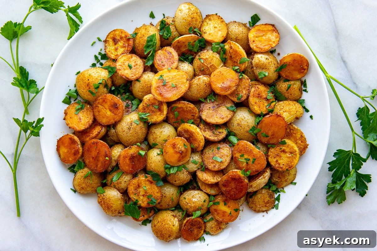 a white circular platter full of roasted baby potatoes.