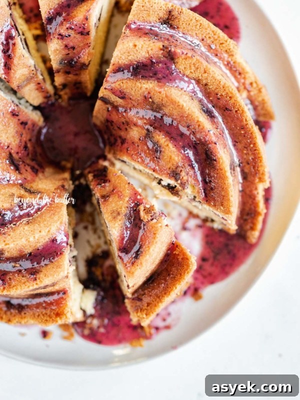 Overhead image of sliced blueberry bundt cake with blueberry glaze drizzled over the top.