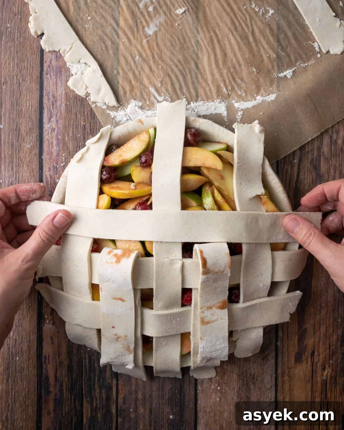 A lattice grid being placed on top of an unbaked pie.