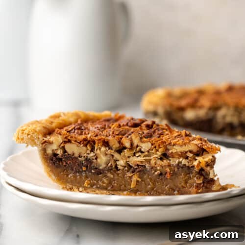 A slice of german chocolate pecan pie on a white plate.