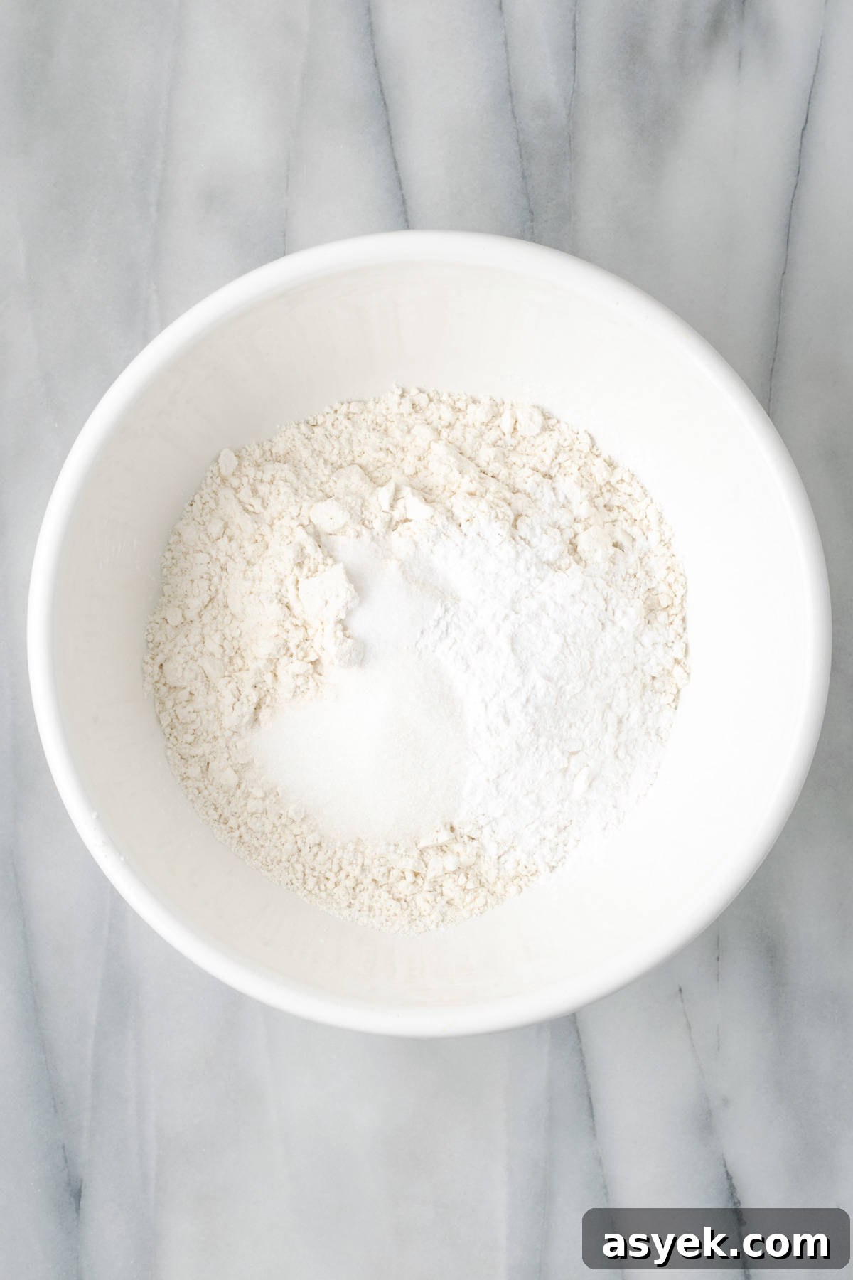 Gluten free flour, starch, sugar and salt combined together in a large white bowl.