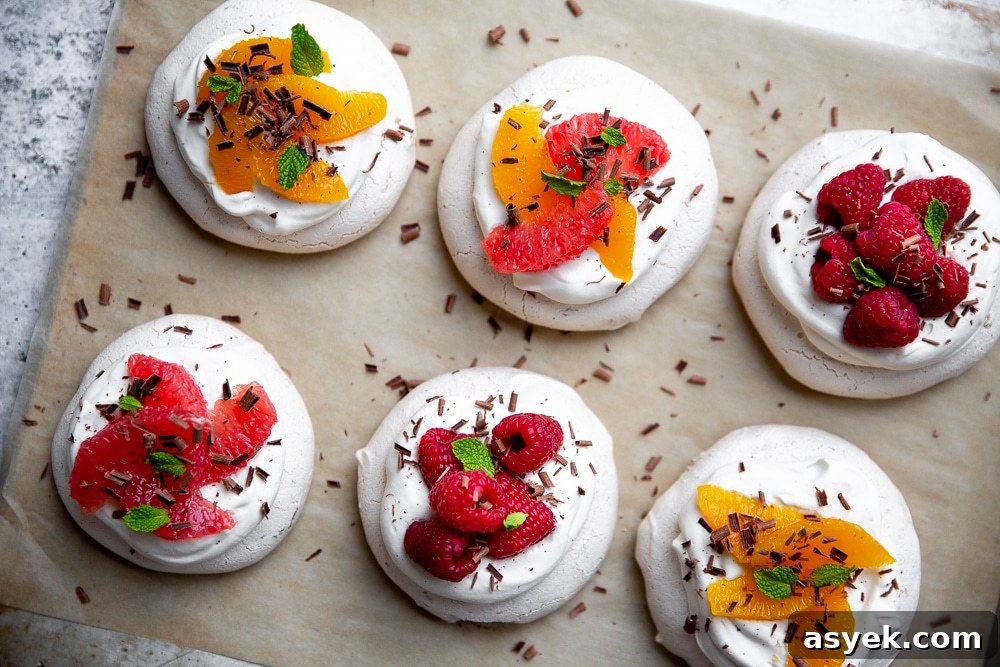 Overhead shot of mini pavlovas lined up on parchment paper. 