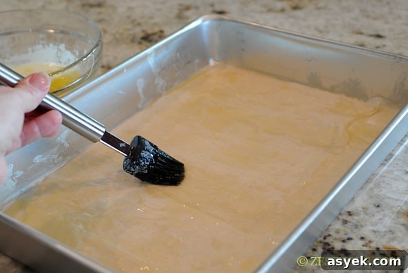 phyllo dough in a pan with butter brushed on it