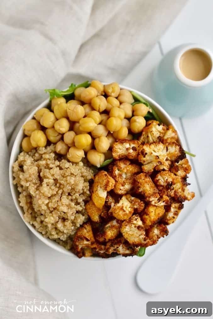 overhead shot of vegan Quinoa Bowl with Roasted Cauliflower, chickpeas and Tahini Dressing on the side