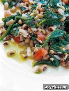 One-Pot Black-Eyed Peas with Spinach Recipe 3 Black-eyed peas, spinach, red onion, and red pepper on a white plate.