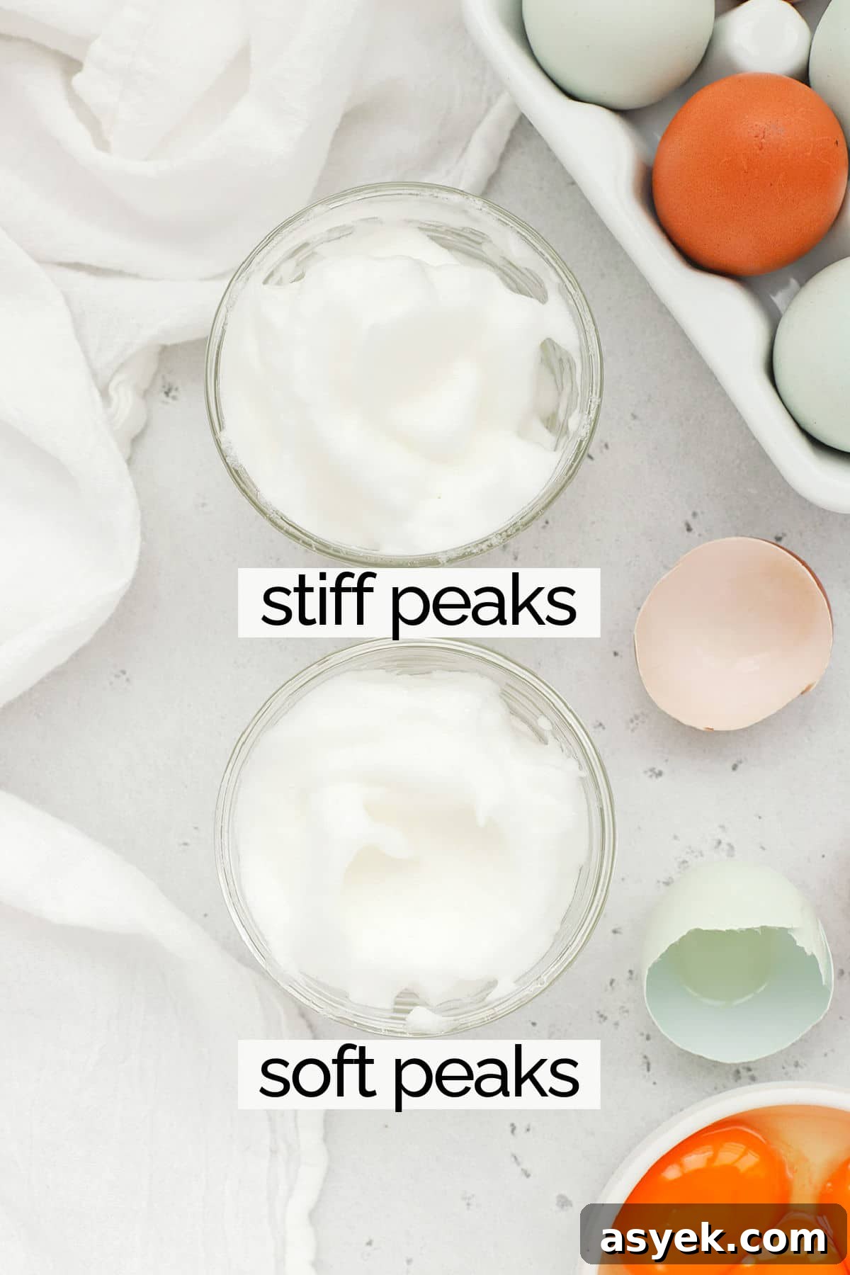 Overhead view of a bowl of egg whites whipped to soft peaks and a bowl of egg whites whipped to stiff peaks