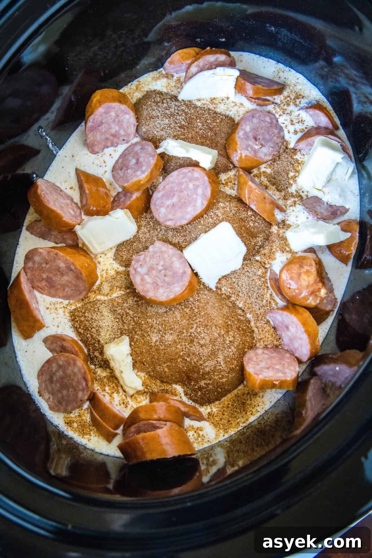 Cajun chicken ingredients assembled inside the slow cooker.