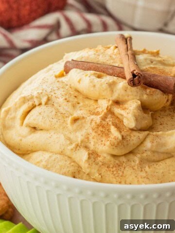 Homemade Pumpkin Cinnamon Rolls with Maple Glaze 13 Whipped pumpkin cream cheese dip in white bowl with cinnamon sticks.